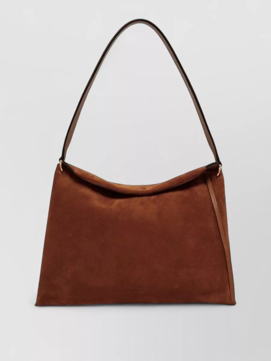 Wandler penelope small leather shoulder bag — The Wandler rust suede shoulder bag quietly tracks the jacket and dress tones and its clean trapeze shape keeps the ensemble modern and minimal rather than overtly bohemian.