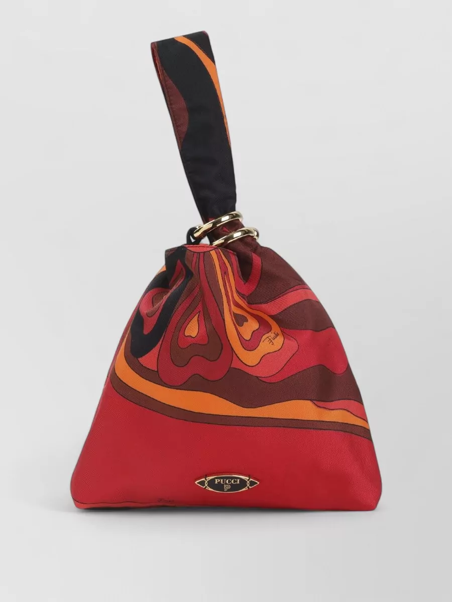 Pucci Silk printed clutch bag — The Pucci mini pouch in vivid red and orange continues the house print story and warm spectrum from the leggings without introducing a new motif, reading polished but still fun on the wrist.