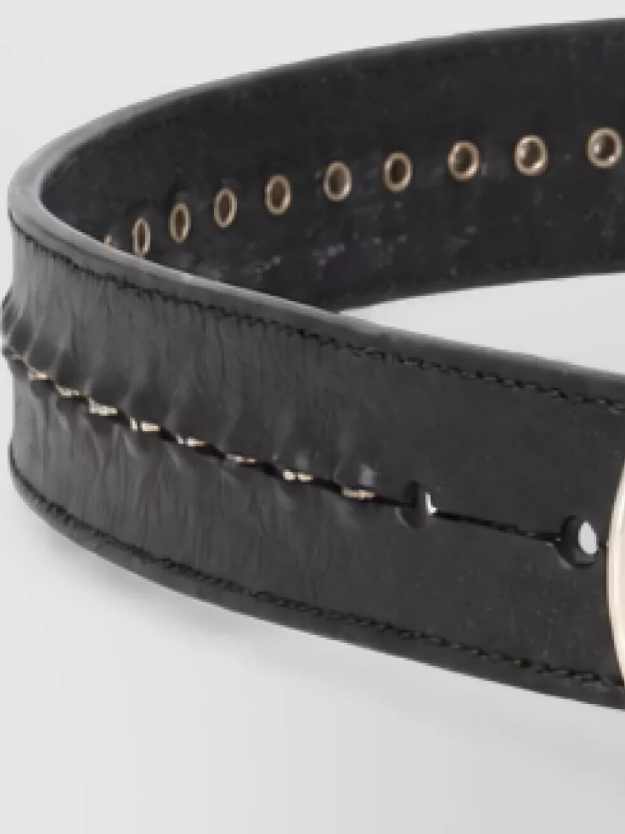 Golden Goose Studded leather belt — The wide black eyelet belt in A grounds the loose high-rise jeans, adds subtle hardware that speaks to the sneakers and moto details, and sharpens the waist within the oversized proportions.