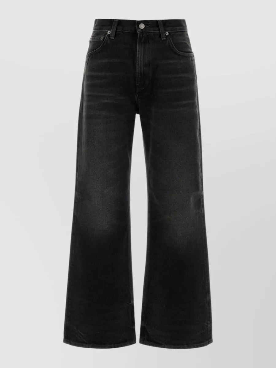 Haikure Denim wide-leg jeans — The high-waist, wide-leg Haikure jean in washed black grounds the faded blue jacket with a long, modern line and cohesive brand-story, avoiding blue-on-blue overload while staying firmly in a streetwear register.