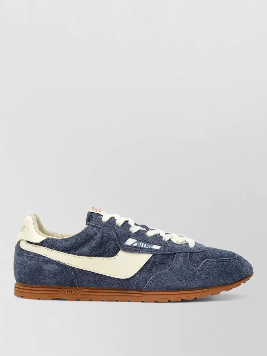 Autry Low-top sneakers — The navy and cream runners echo the joggers’ colour and the hoodie’s contrast drawcord, keeping everything Autry and cohesive while the cream sole lightens the all-navy base.