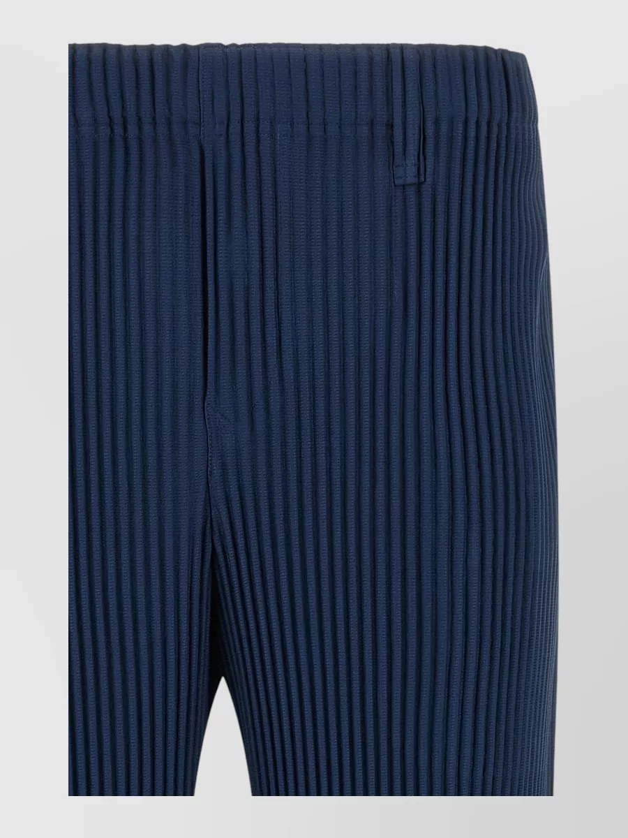 Homme Plisse Issey Miyake Pleated straight-leg trousers — The deep navy straight-leg pleated trouser keeps the silhouette clean and architectural while grounding the acid yellow top with a calm, technical contrast that matches its minimalist sport energy.