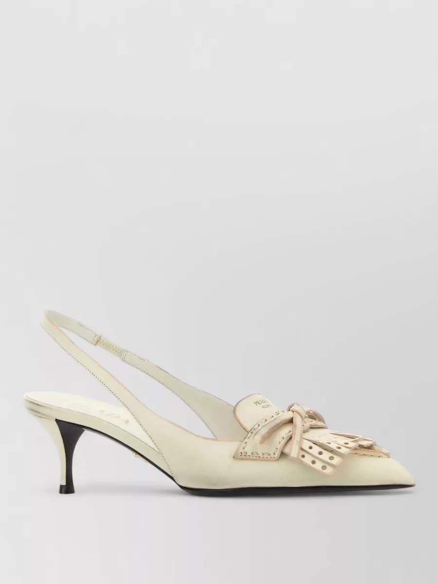 Prada Leather mules — The buttercream Prada kitten-heel slingbacks echo the ivory of the top, keep the mood romantic and polished, and add just enough height for a balanced cocktail silhouette without heaviness.