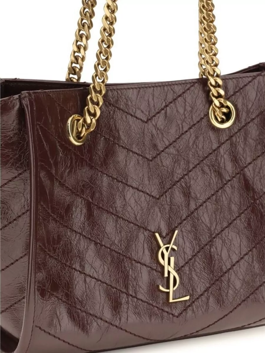 Saint Laurent Calf leather shoulder bag — The Saint Laurent deep chocolate quilted tote matches the coat’s richness and the city polish of the tailoring, reading luxurious yet practical for daytime with cohesive gold hardware.
