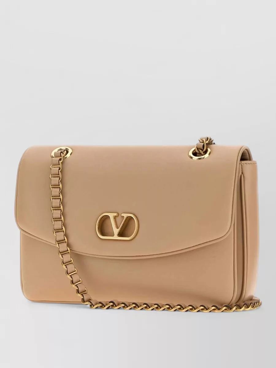 Valentino Garavani Leather clutch bag — The nude-beige Valentino flap bag echoes the shoe shade and lace romance with clean structure, adding just enough polish for going out without overwhelming the delicacy of the fabrics.