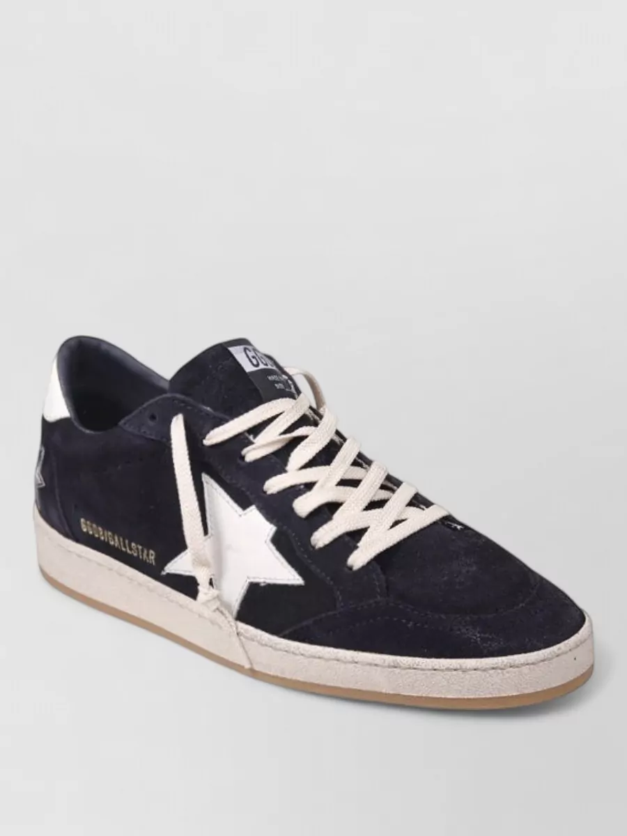 Golden Goose Leather low top sneakers — The navy Golden Goose sneakers sit in the same palette and casual street-sport mood as the knit and cargos, with just enough texture and contrast to keep the outfit from feeling flat.