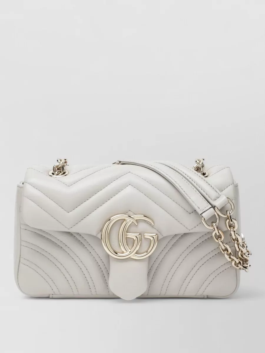 Gucci gg marmont small nappa leather shoulder bag — The small ivory quilted flap bag keeps the palette light and refined, tying into the metallic notes of the skirt and shoes while maintaining the outfit’s polished, evening-ready formality.