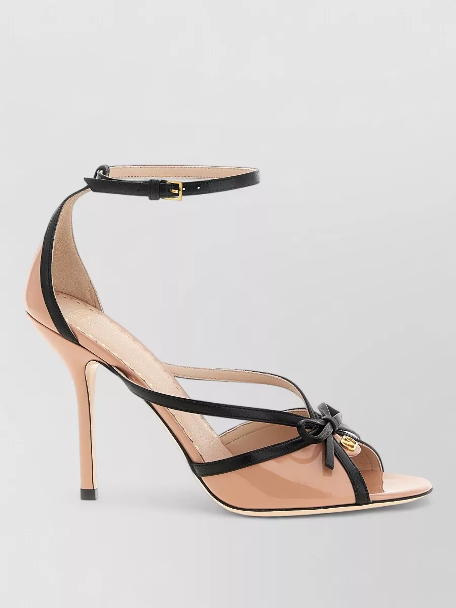 Valentino Garavani Leather sandals — The nude-and-black stiletto sandal in F picks up the skirt’s black waistband and keeps the look refined and feminine, while the barely-there straps let the printed blouse remain the focal point.