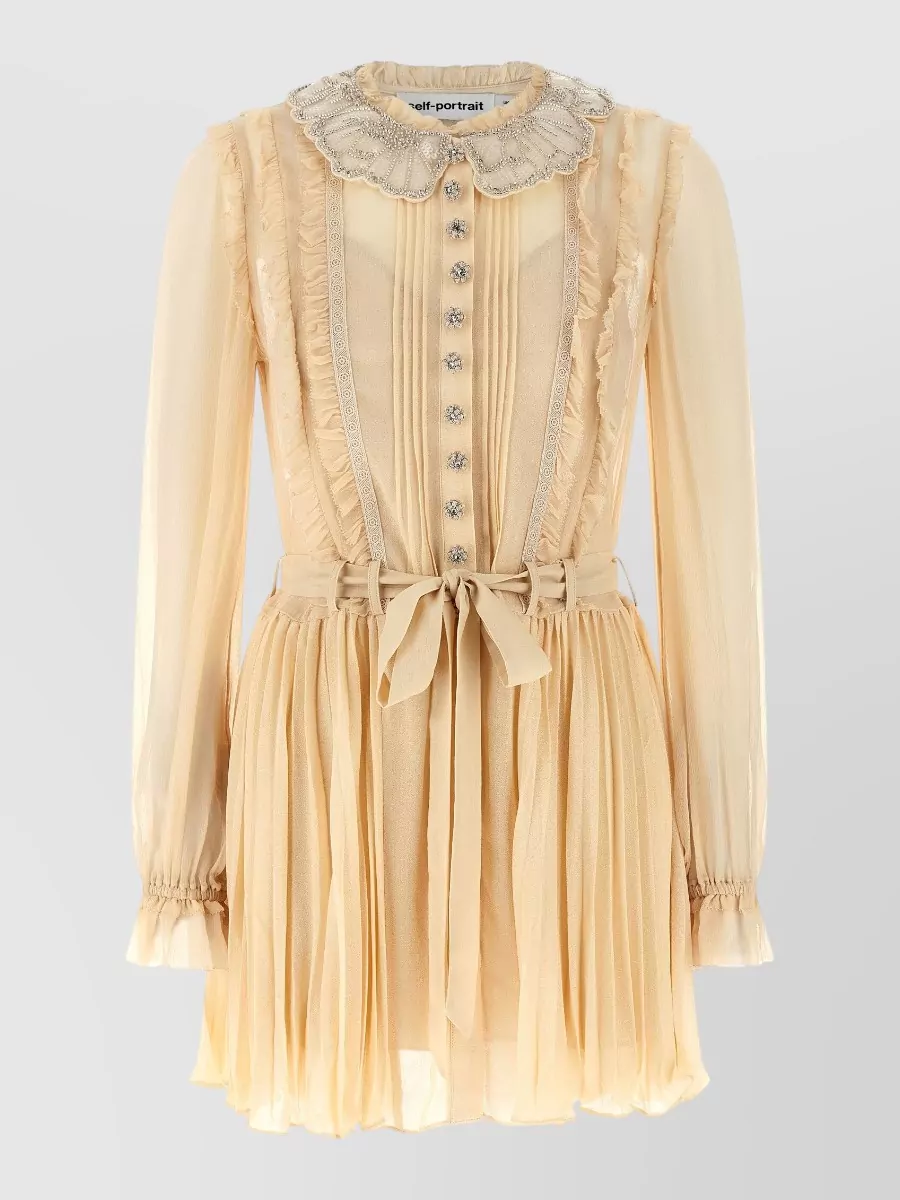 Self-Portrait Pleated georgette mini dress — The ivory knit mini with black contrast detailing mirrors the source jacket’s Parisian tweed aesthetic and palette, creating a coordinated, polished mini-dress moment that feels like a matching set.