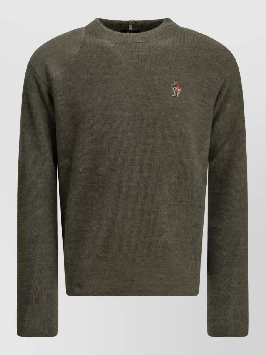 Moncler Grenoble Virgin wool crew neck sweater — The olive crew knit quietly aligns with the jacket’s green tones and alpine mood without adding bulk, keeping the layering cohesive and relaxed-luxury.