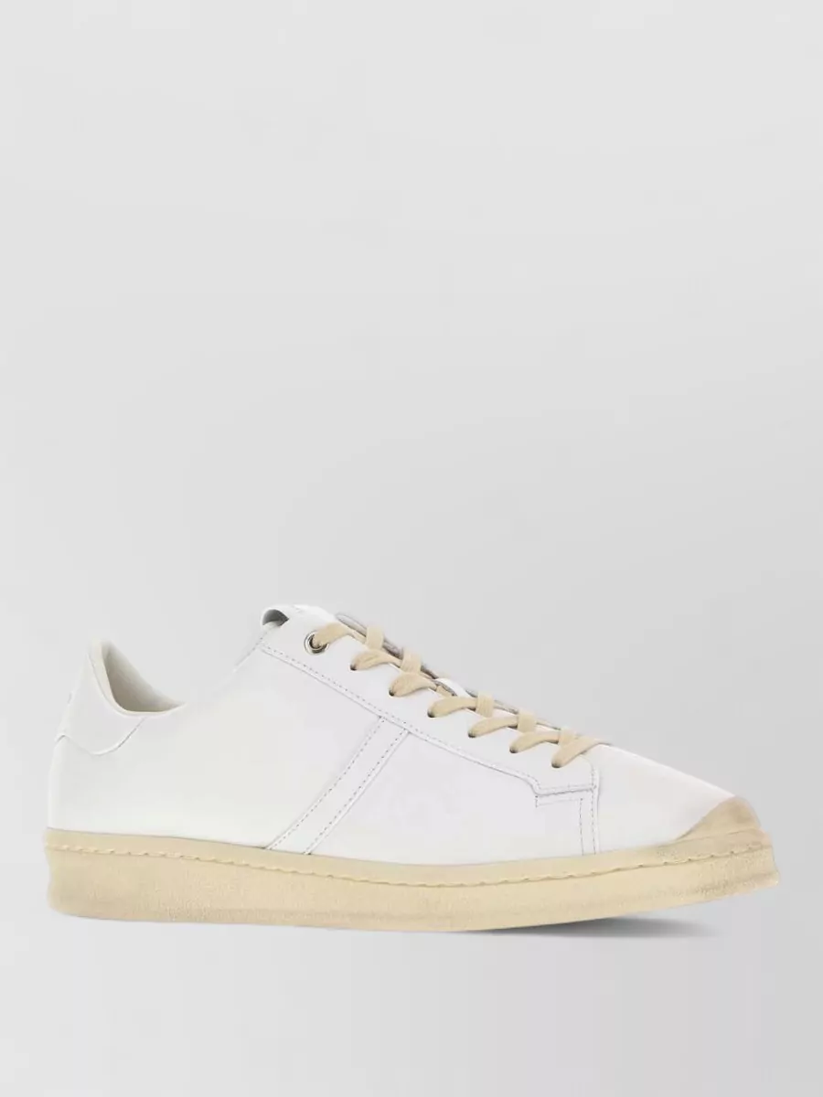 Jil Sander Leather low-top sneakers — Sneaker A, in soft white with a warm beige sole, directly picks up the tee’s warm tan stripe and ivory tones, grounding the outfit in a minimalist, relaxed but polished way.