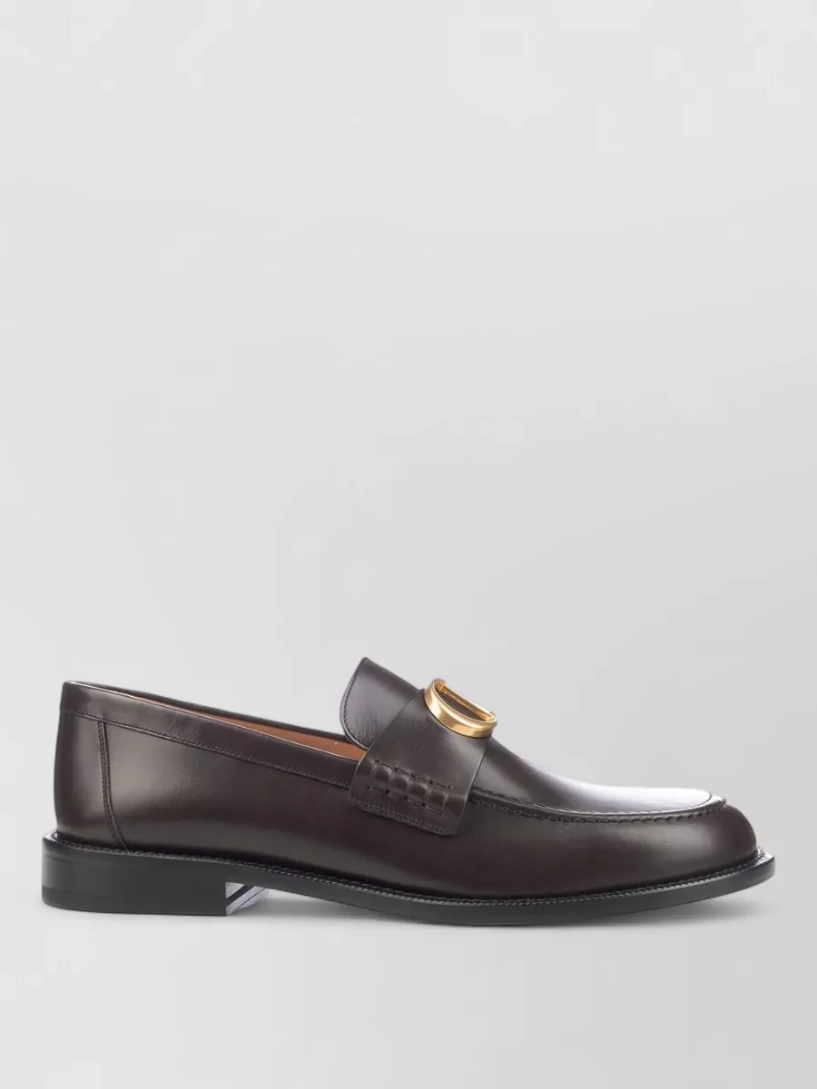 Christian Dior Leather loafers — Dior’s dark brown loafers hit the right formality and pick up the coat’s dark collar, grounding the neutrals with a sharp but not overbearing finish.