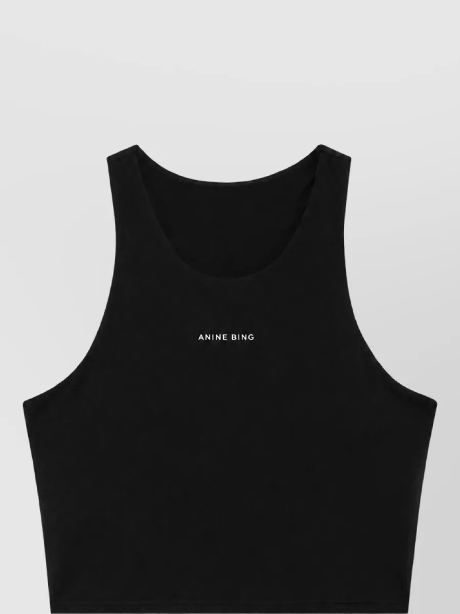 Anine Bing Stretch jersey bralette — The black cropped racerback tank mirrors the leggings' minimalist sport aesthetic and logo detailing, creating a clean monochrome set that works for studio sessions and off-duty layering.