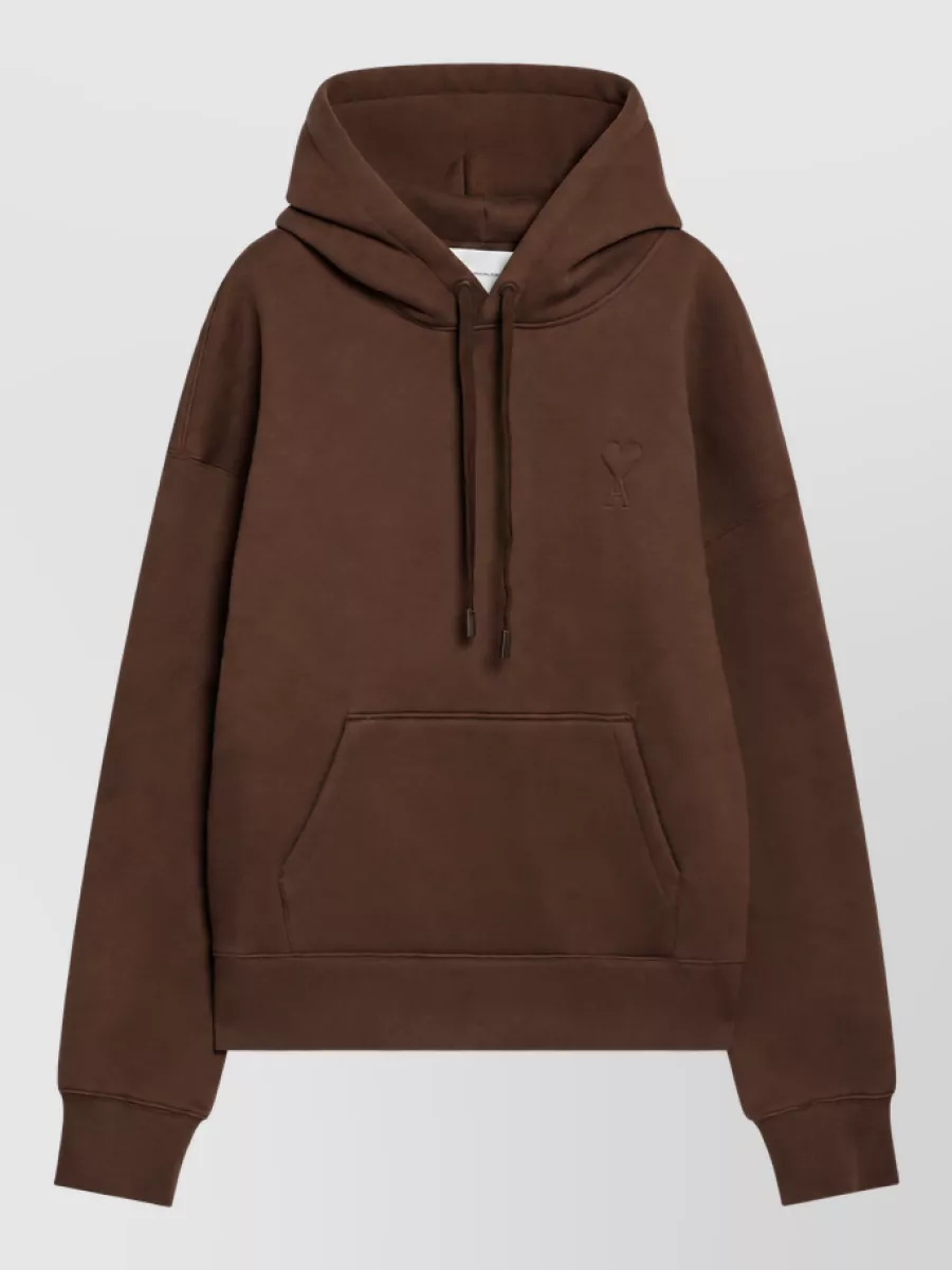 Ami Paris Hoodie — The Ami chocolate hoodie mirrors the beanie’s brown base and red-accented, quiet-luxury streetwear mood, giving a rich tonal top block that still feels relaxed and urban.