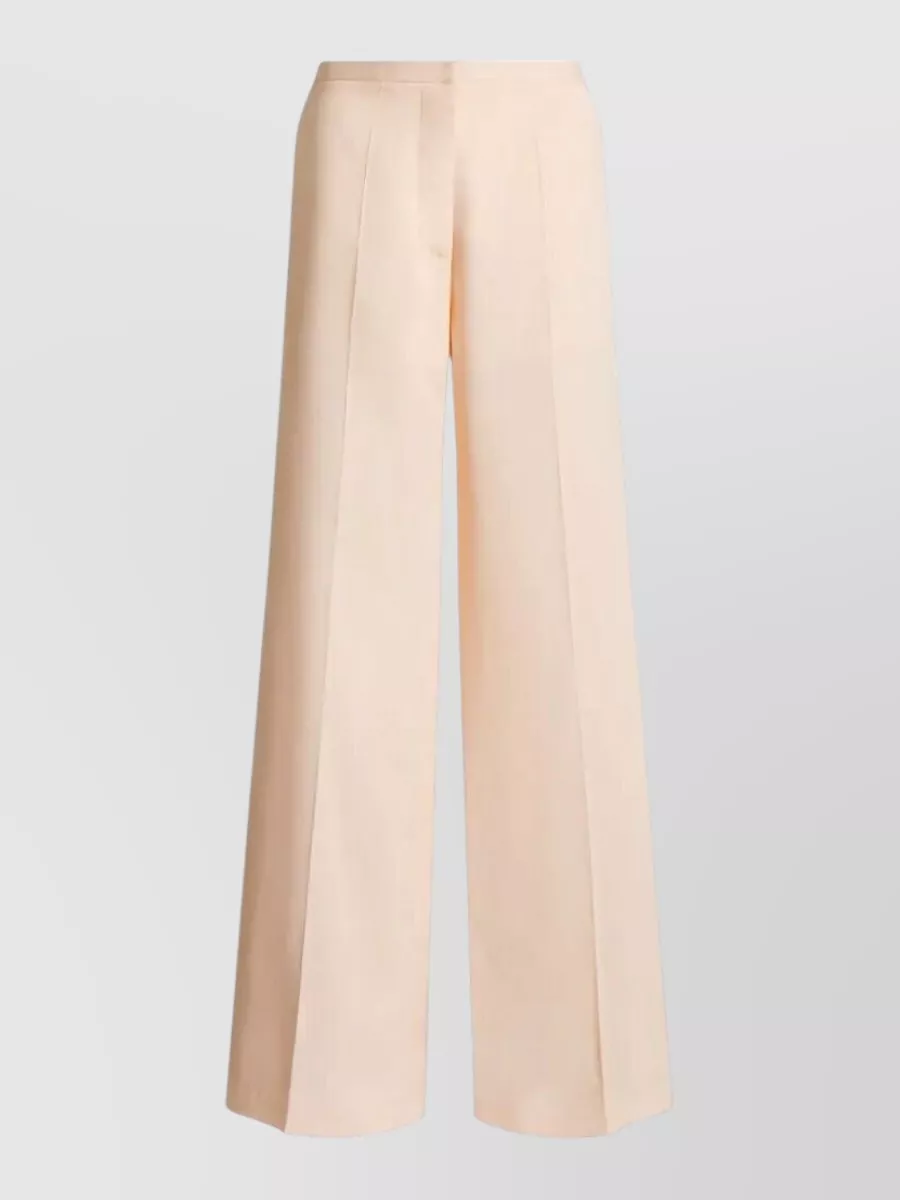 Alberta Ferretti Wide-leg trousers — The soft vanilla high-waisted fluid wide-leg trouser gives a clean, luminous counterpoint to the bold leopard poncho, matching its SS formality while keeping the silhouette elongated and quietly romantic.