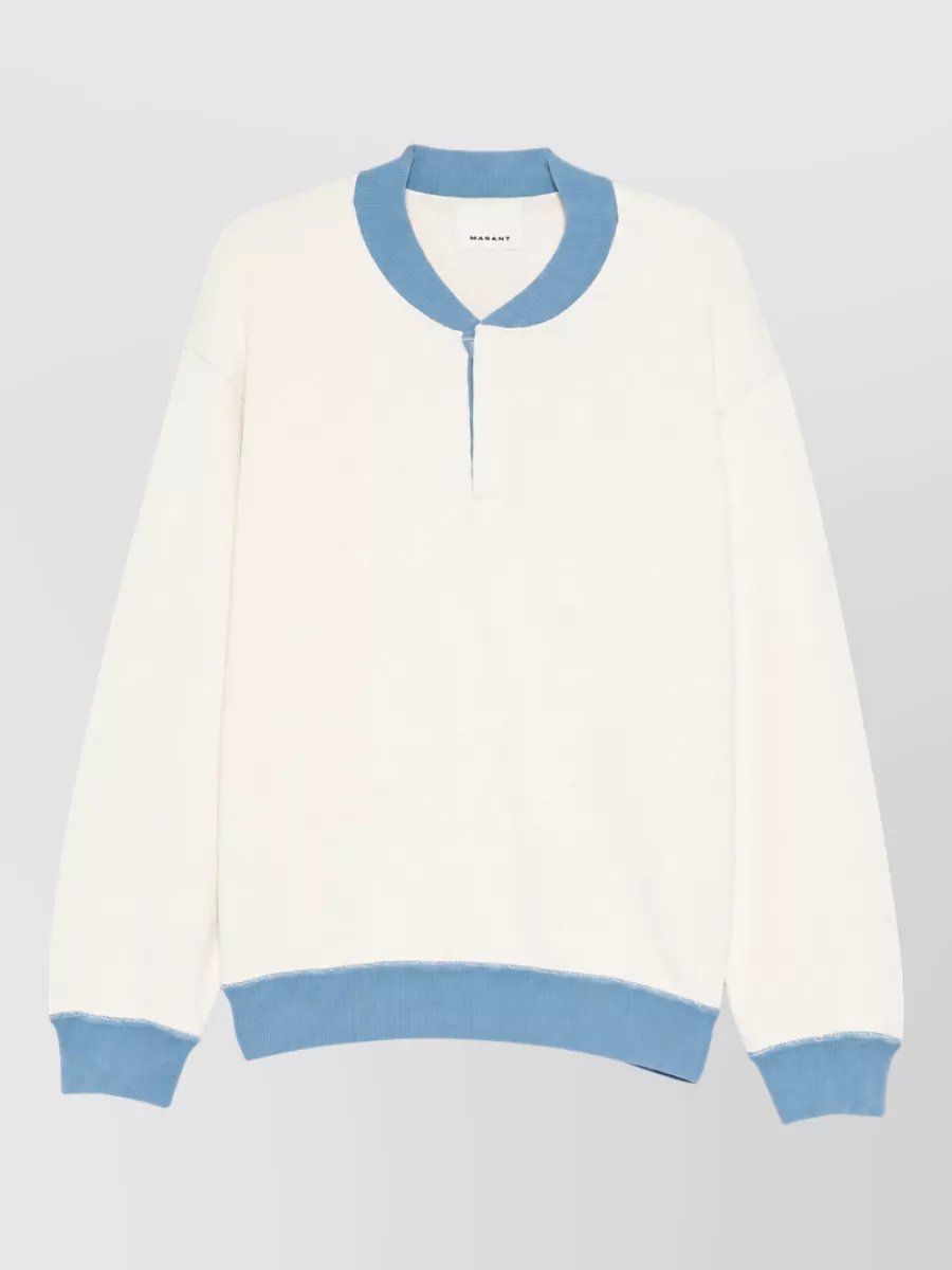 Isabel Marant Cotton tank top — The Isabel Marant long-sleeve with sky-blue trims mirrors the mule’s powder tone and keeps the vibe sporty streetwear without losing the boutique, quiet-luxury edge.
