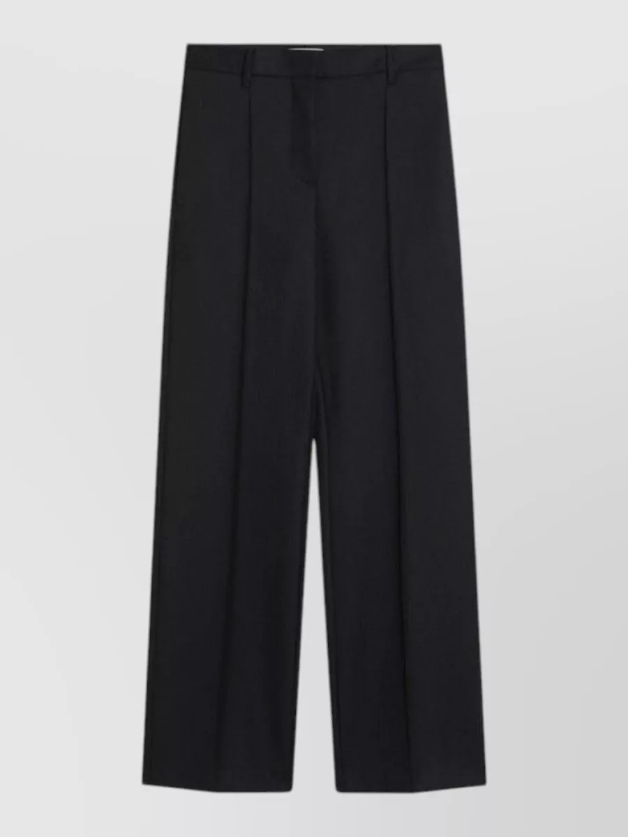 Prada Wool wide-leg trousers — The high-rise black wide-leg trouser delivers a long, architectural line that pairs perfectly with the chunky loafers and reads polished yet modern for city dressing.