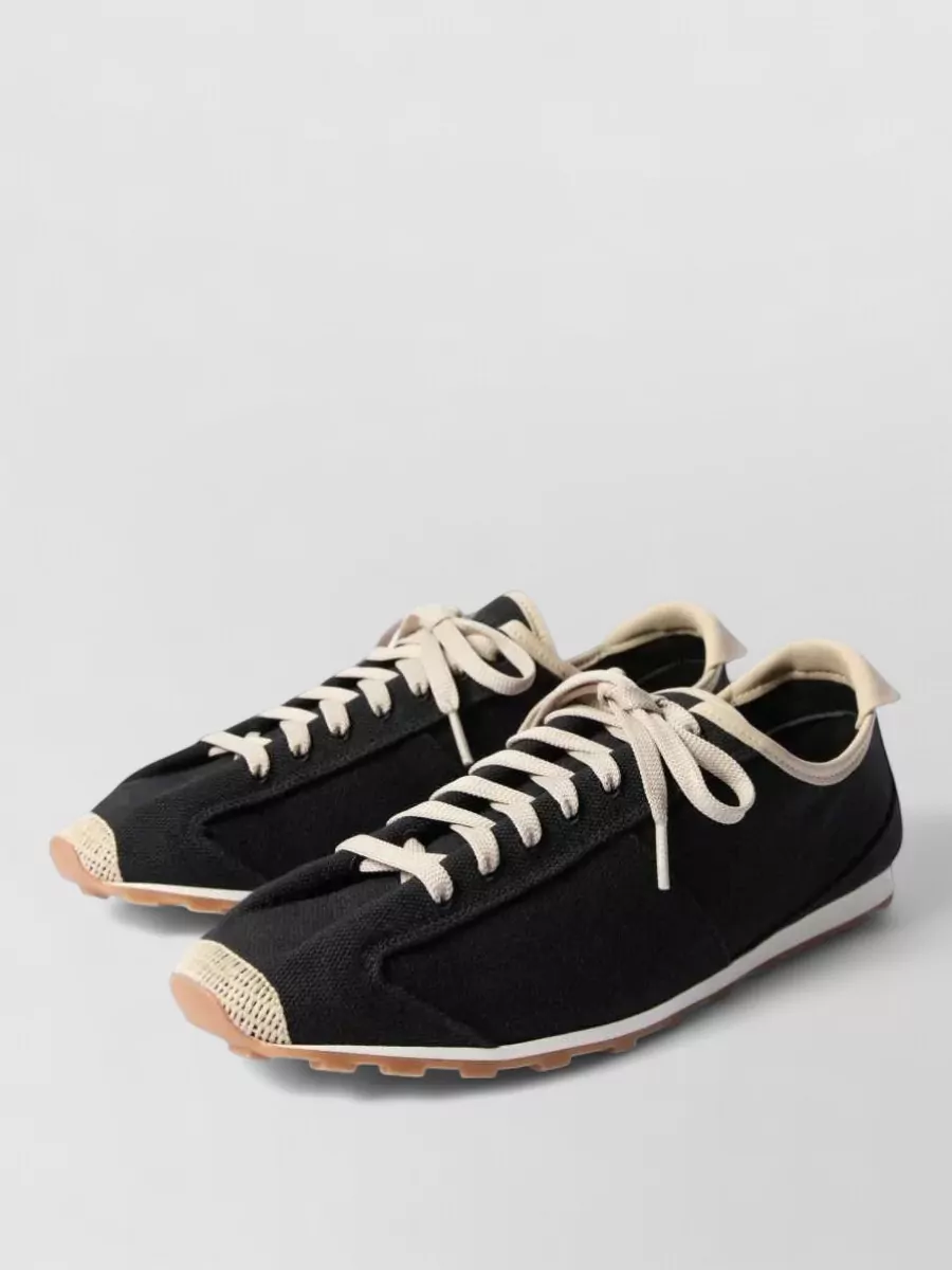 Jacquemus Cotton low-top sneakers — The black and cream Jacquemus retro runners echo the polo’s sport edge, tie into the darker side panels, and sit nicely against the cream cargos for a grounded yet light feel.