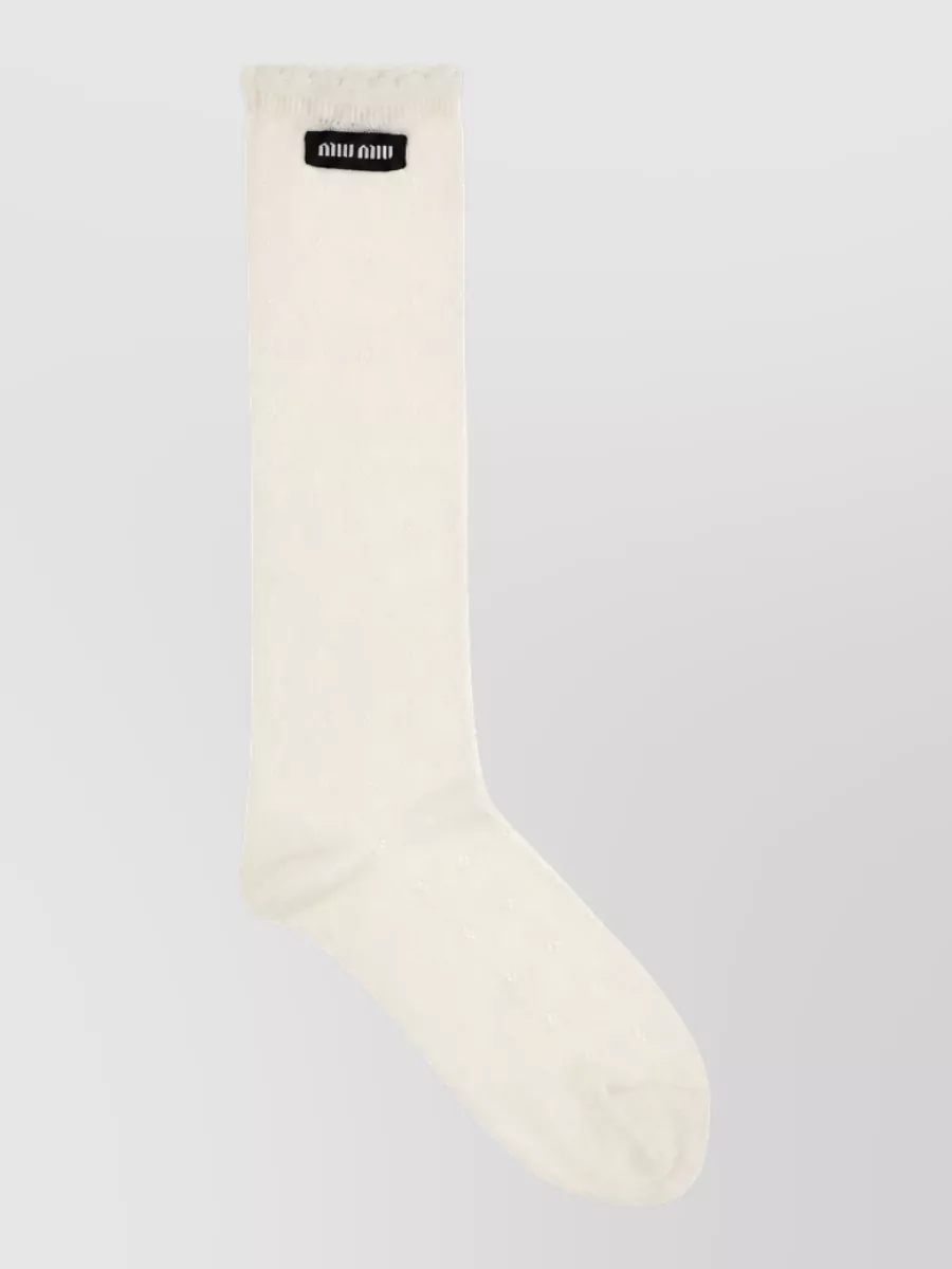 Miu Miu Cotton pointelle knee-high socks — The ivory logo knee-high socks complete the subversive-schoolgirl story, adding a soft contrast between the dark shoes and mini that still feels polished rather than costume.