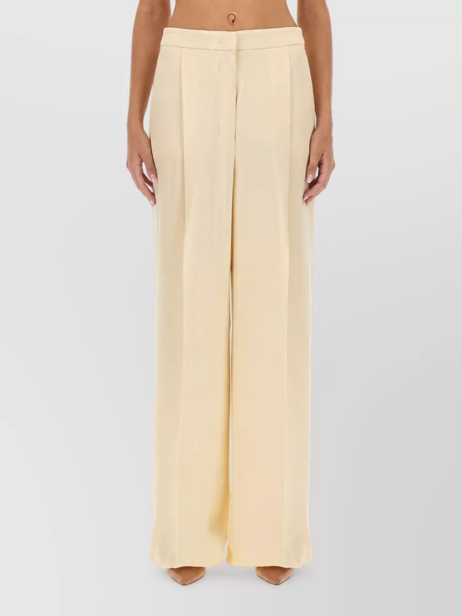 Max Mara Silk wide-leg trousers — Max Mara K keeps the soft neutral column with a high-waisted fluid wide leg that mirrors the blouse’s relaxed drape while adding just enough tonal contrast for depth.