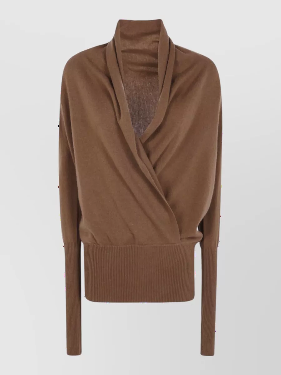 7 For All Mankind Cashmere wool v-neck wrap sweater — The warm camel wrap knit softens the light beige denim and respects the high-rise wide leg with a defined ribbed hem that keeps proportions balanced and quietly refined.