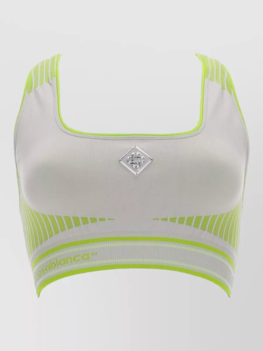Casablanca Seamless bralette top — The white mesh polo with navy and sky stripes mirrors the skirt’s perforation, colours and tennis energy, creating a clean, cohesive court-set rather than introducing lime contrast.