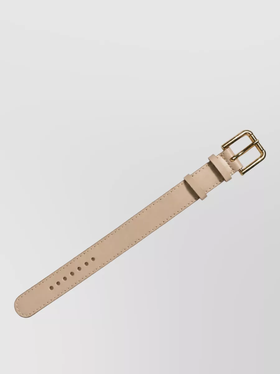 Dolce&Gabbana Calf leather belt bracelet — Accessory K’s slim nude belt can sit over or in place of the dress’s tie to define the waist with a barely-there line that preserves the soft tonal palette and minimalist aesthetic.