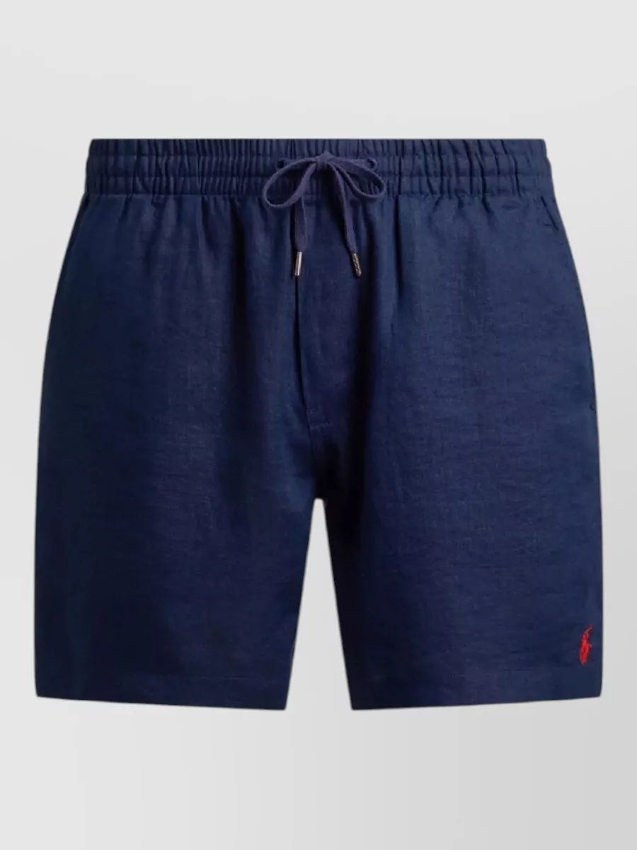 Polo Ralph Lauren Linen swim shorts — The navy swim shorts with a red pony mirror the tee’s black‑and‑red story while keeping the vibe clean, preppy and warm‑weather casual at the same formality level.