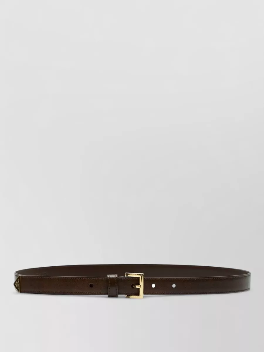Prada Leather slim belt — The slim chocolate belt introduces a subtle waist definition and a refined leather accent that quietly ties the deep charcoal and espresso tones together.