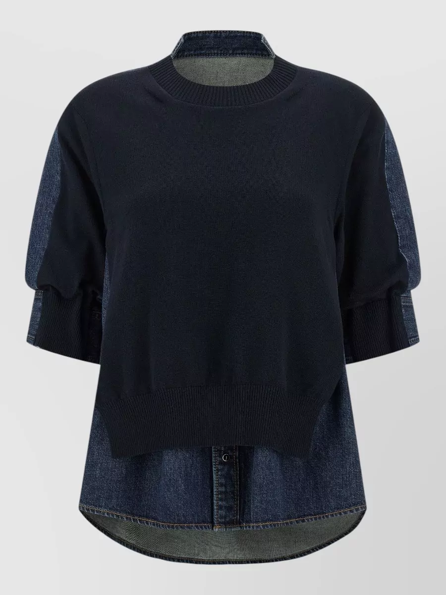 Sacai Denim panelled short-sleeve sweatshirt — The navy knit and denim hybrid top from Sacai mirrors the skirt’s pleated denim structure and dark-indigo palette, creating a cohesive, directional streetwear-tailored set in the same brand universe.