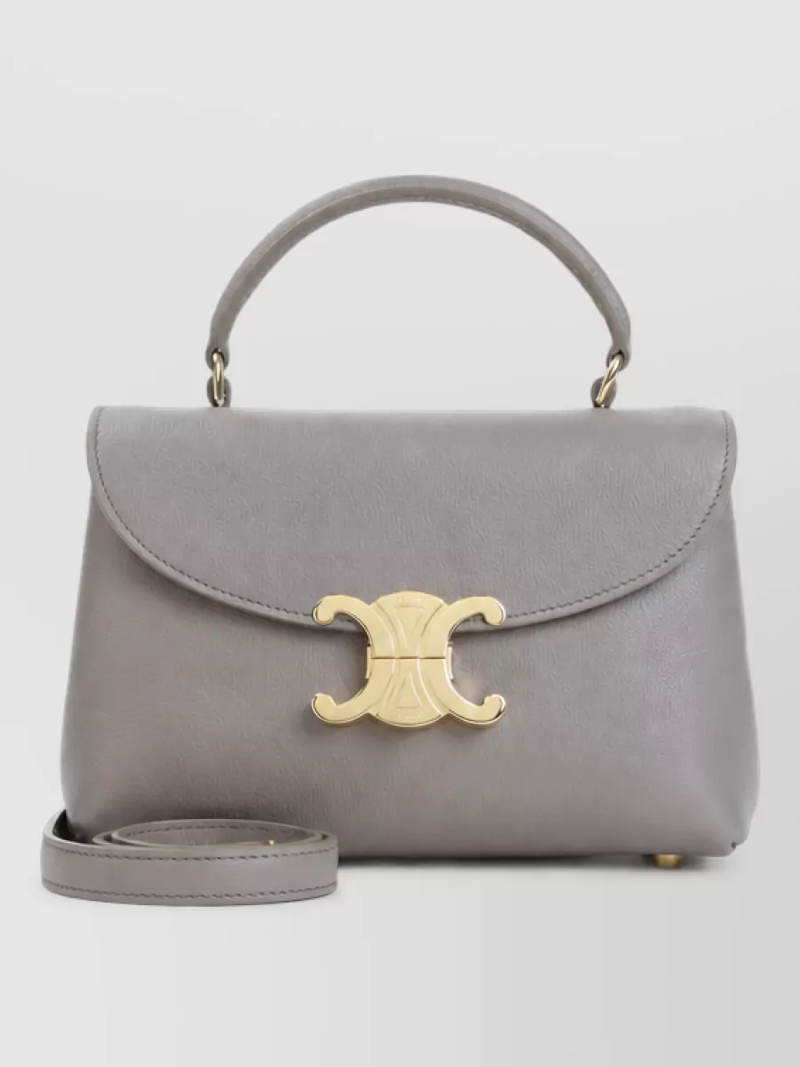 Celine Calfskin leather shoulder bag — The Celine taupe top-handle offers structured, quiet-luxury contrast to the soft florals and wide-leg silhouette, its cool grey tone sitting calmly between the shirt’s slate blues and inky blacks.