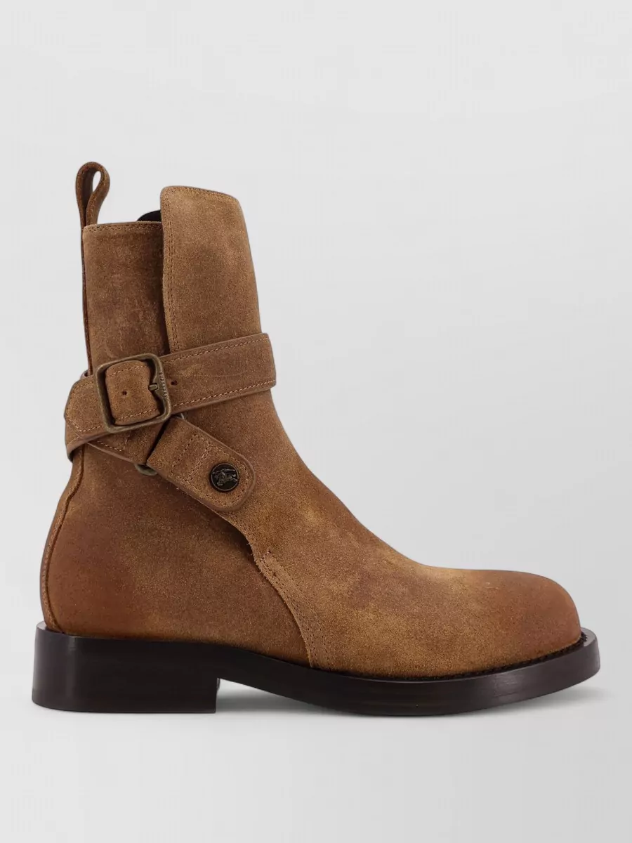 Burberry Suede boots — The camel suede ankle boots with a low block heel quietly echo the trench’s heritage utilitarian feel and warm up the monochrome without breaking the polished, city-appropriate line.