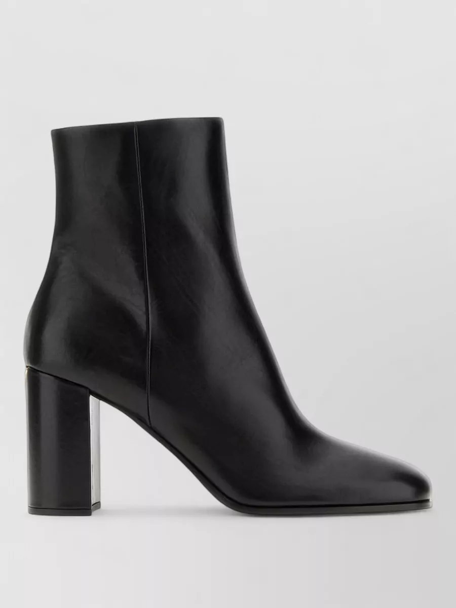 Prada Leather ankle boots — Prada’s sleek black ankle boot keeps the line clean under the flared hem, matches the trouser’s formality, and grounds the outfit with modern, quiet-luxury structure for fall evenings.