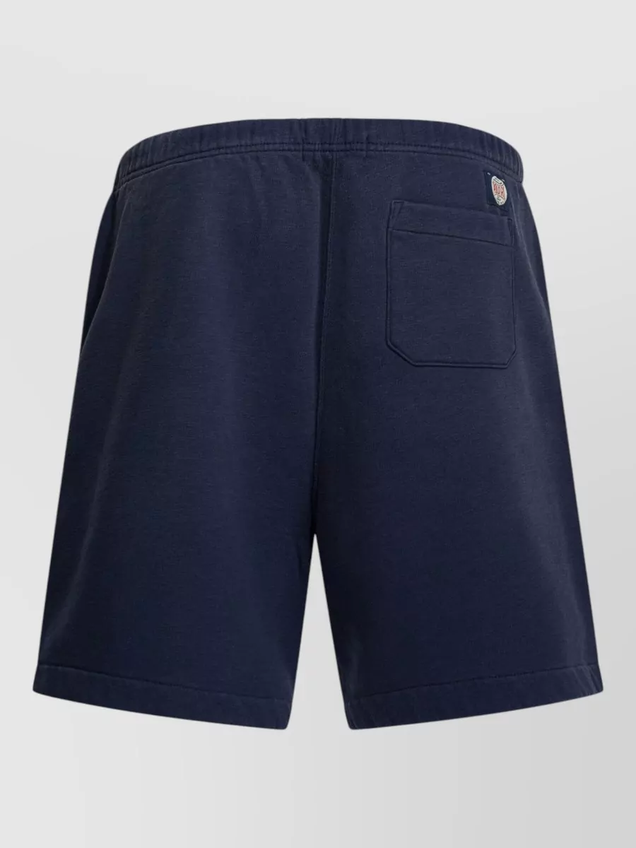 Polo Ralph Lauren Cotton logo deck shorts — The clean navy deck short with subtle pony mirrors the tee’s minimalist preppy-sport attitude and keeps a unified navy base so the tartan logo detail stays the quiet focal point.