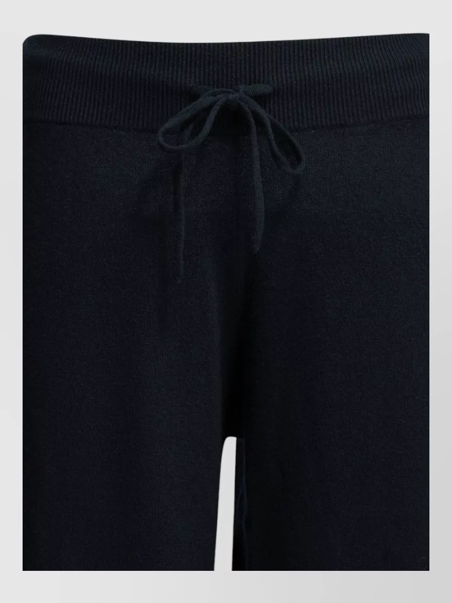Lisa Yang Cashmere pyjama trousers — The matching navy wide-leg knit from Lisa Yang creates a monochrome, cocooning column that perfectly mirrors the cardigan’s relaxed quiet-luxury mood while staying lounge-polished rather than sloppy.