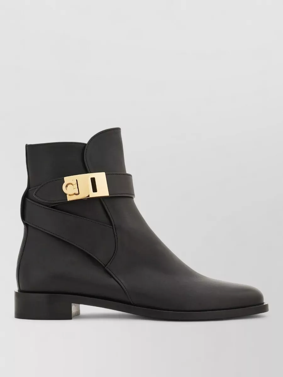 Ferragamo Leather ankle boots — The Ferragamo black ankle boots with a subtle gold buckle echo the top’s beaded neckline and ground the outfit with sleek, tailored structure appropriate for work and dinner.