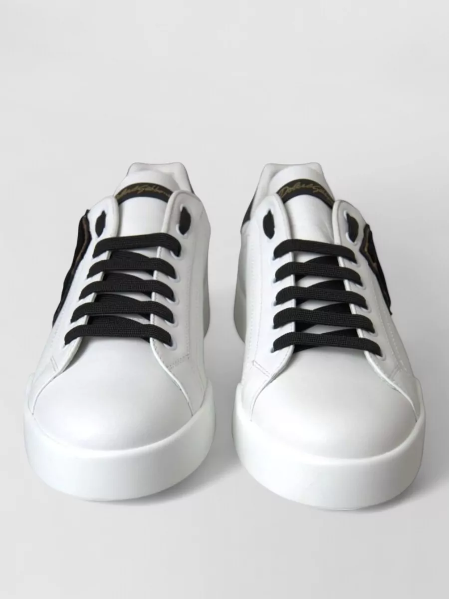 Dolce&Gabbana Leather low-top sneakers — The black low-top sneaker with a white midsole reinforces the monochrome palette and quiet-luxury streetwear angle, while the slightly dressier finish works with tailored trousers.