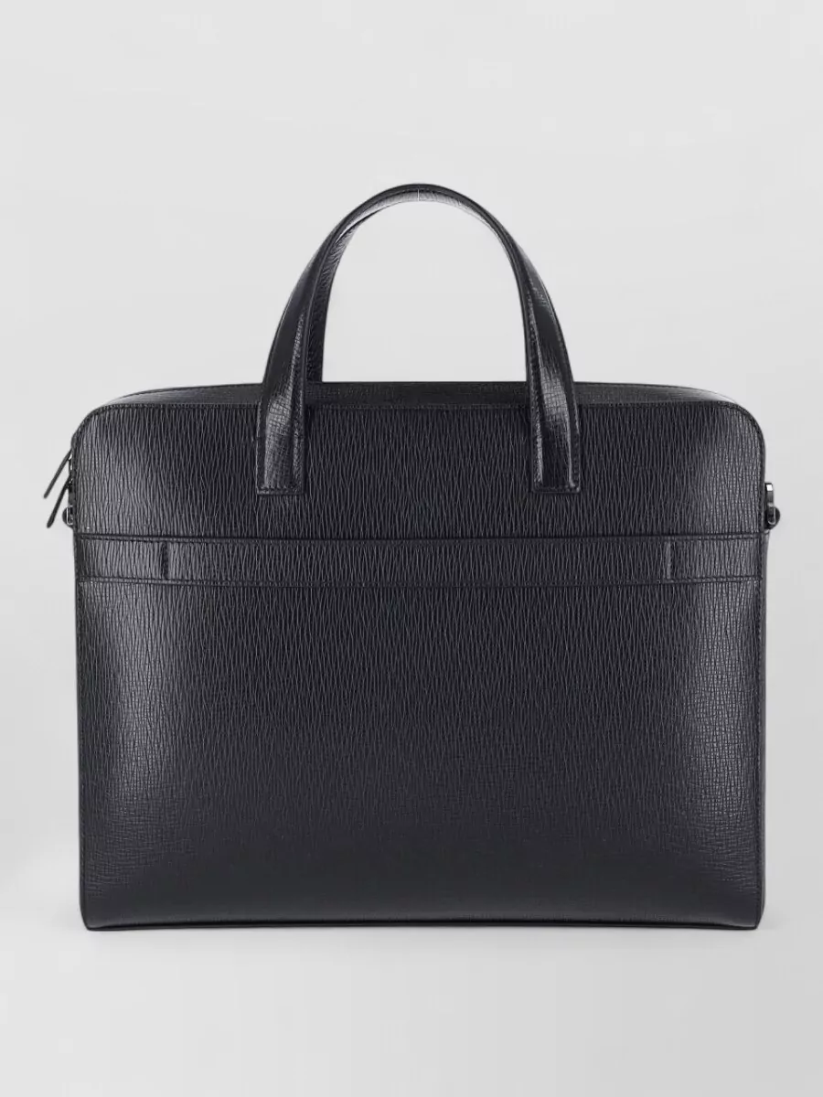Ferragamo Leather briefcase — The Ferragamo slim black briefcase aligns with the tailored formality and quiet-luxury briefcase language of the Prada blazer while keeping the silhouette sharp and unobtrusive.