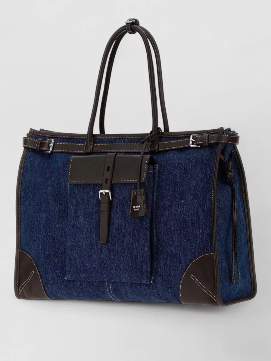 Prada Denim tote bag — Prada’s inky denim and dark-brown oversized tote reinforces the quiet-luxury denim story and brings a sophisticated, functional scale that works with casual tailoring and premium jeans.