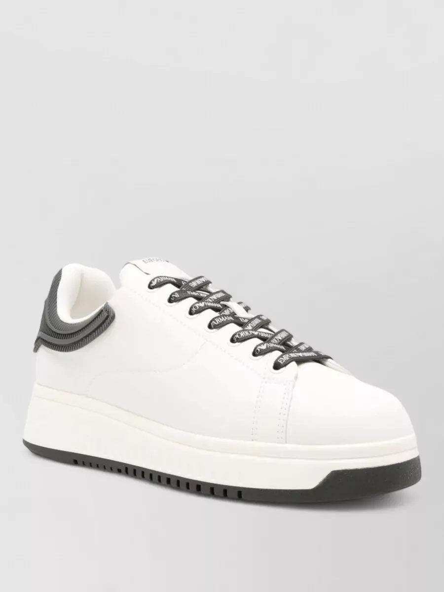Emporio Armani Leather low-top sneakers — The off-white chunky-sole sneakers pick up the light tee option, keep the monochrome story tight, and sit at the right streetwear-meets-quiet-luxury level for straight black trousers.