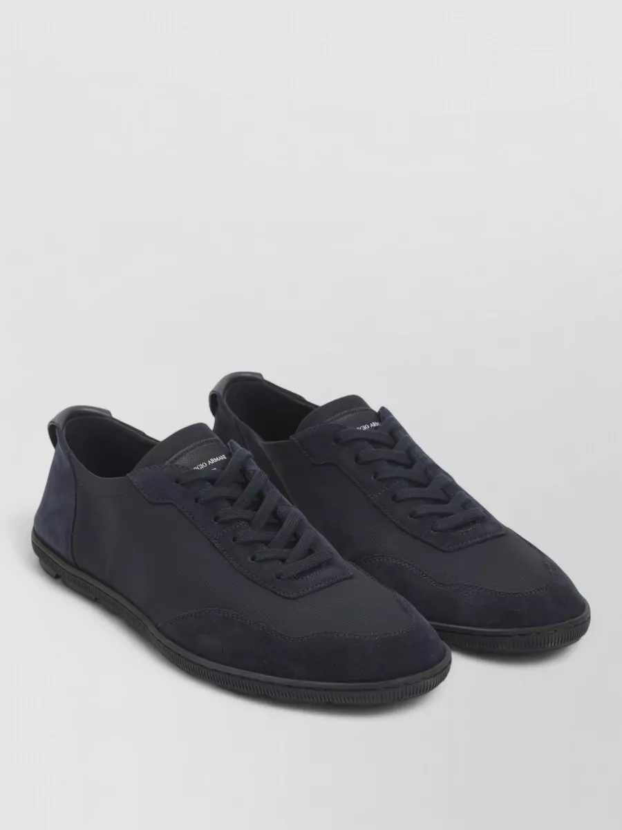 Giorgio Armani Leather low-top sneakers — The Giorgio Armani navy low-top sneakers keep the outfit cohesive in color and quietly luxurious in attitude, sitting perfectly between tailored and relaxed with the wide-leg trouser.