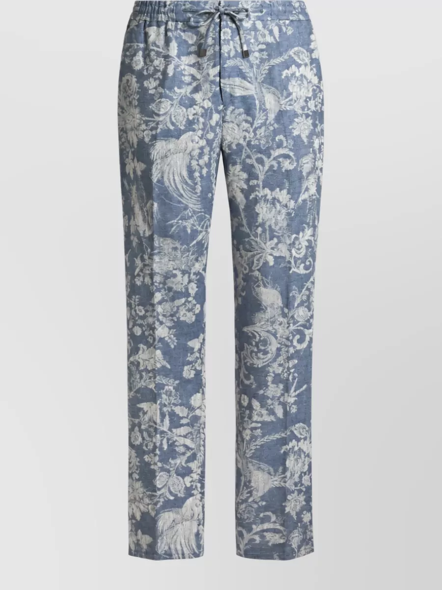 Etro Cotton chino shorts — The dusty-blue floral drawstring shorts mirror the tee’s birds-and-botanicals and sit in the same cool palette, so the all-Etro pairing feels relaxed, romantic and perfectly coastal without clashing prints.