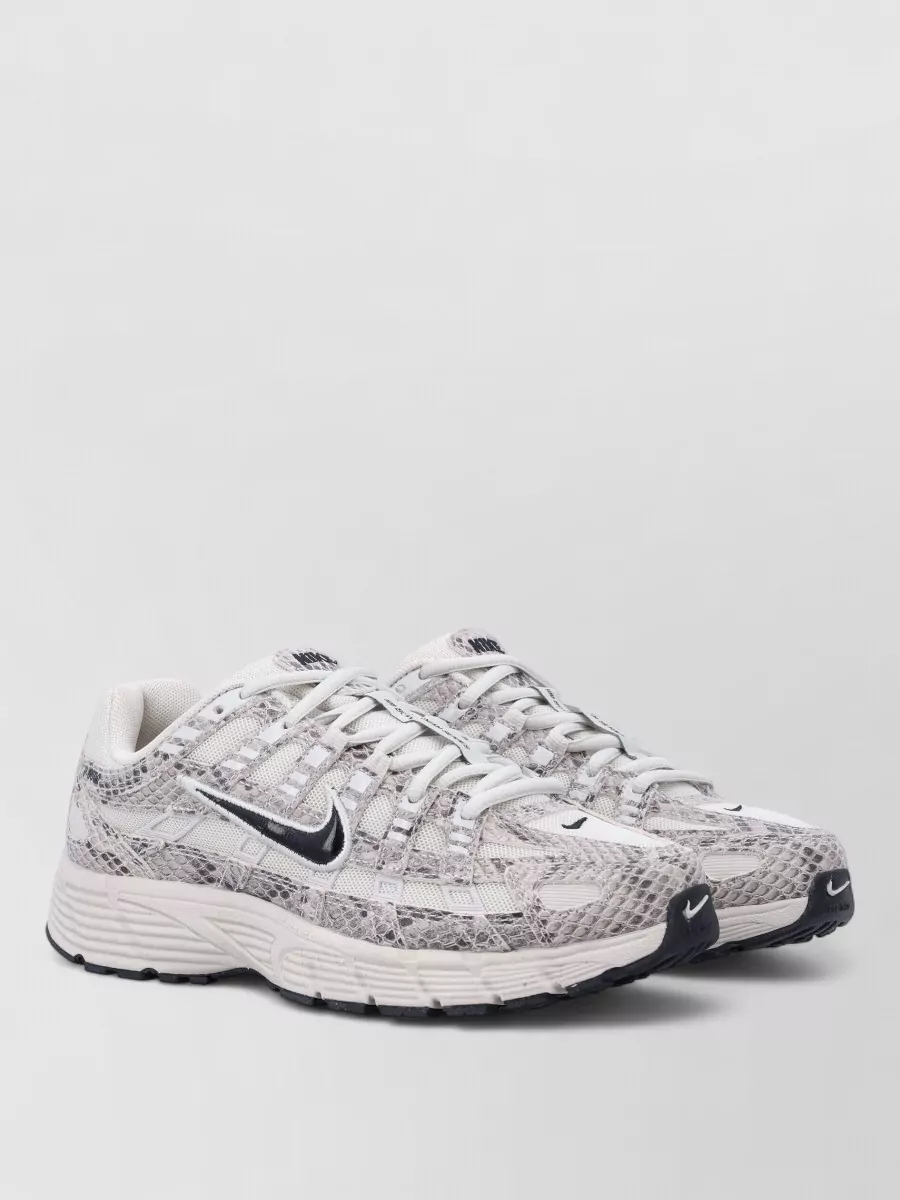 Nike Synthetic low-top sneakers — The off white and taupe Nike runners keep the look firmly in a sport-street space, balancing the dress’ fitted A-line with a grounded retro sneaker that will not fight its bold colours.