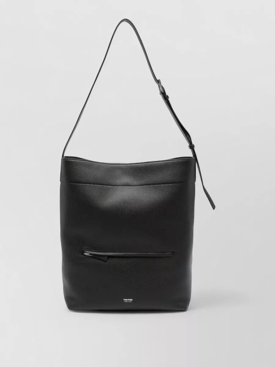 Tom Ford Leather shoulder bag — The black intrecciato Bottega Veneta crossbody offers structured, discreet luxury that pairs effortlessly with navy and corduroy textures without drawing attention away from the knitwear.