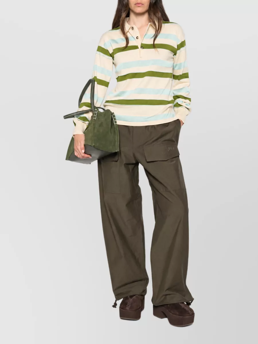 JW Anderson Wide leg pants — The JW Anderson olive cargo wide-leg mirrors the reference styling, pulls out the green from the polo, and keeps a relaxed street-preppy mood at the same brand and price tier.