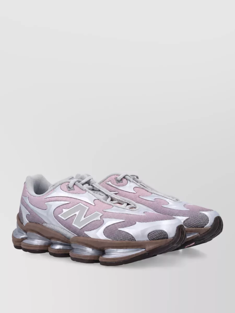 New Balance 2000 low-top sneakers — The New Balance runner in cool grey and dusty mauve hits the Y2K tech-sneaker note, subtly echoes the pink tones, and keeps the outfit firmly in the sport-fashion space.
