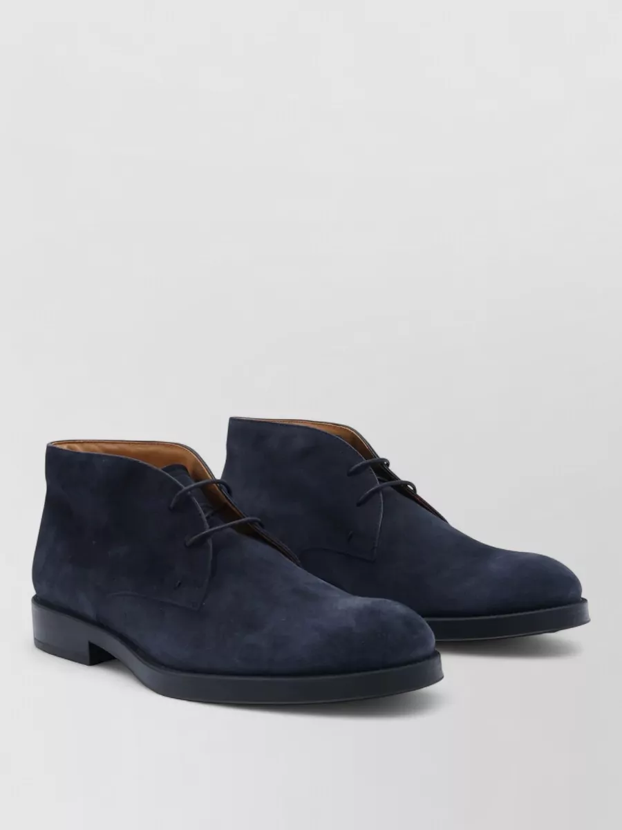 Tod's Suede desert boots — The Tod’s navy suede chukka has the right quiet formality and winter weight, echoing the sweater’s tone while grounding the charcoal trouser in a refined yet relaxed way.