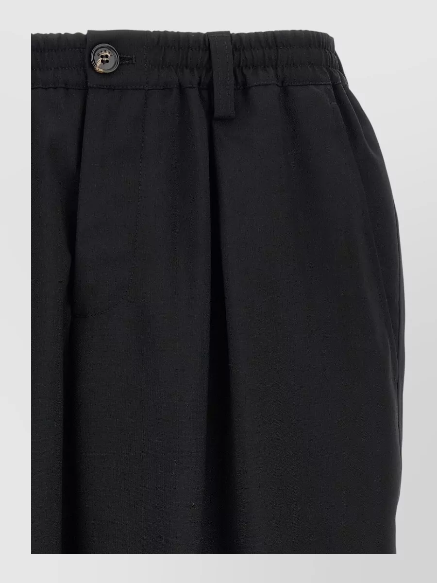 Marni Virgin wool cropped tapered trousers — The relaxed black pleated trouser mirrors the sweater’s relaxed art-school energy, keeps the palette sharp, and balances the bold knit without diluting Marni’s streetwear-preppy mood.