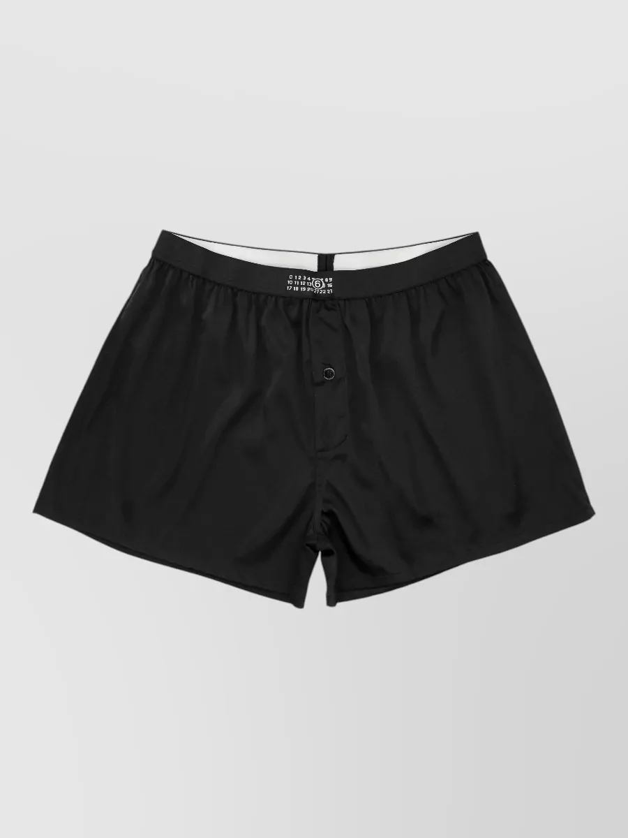 Mm6 Maison Margiela Silk knee-length boxer shorts — The inky wide-leg trouser keeps the tee’s minimalist, street-led energy while adding architectural volume and full-length ease for a clean, quiet-luxury city uniform.