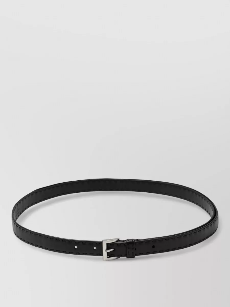 Prada Leather belt — The slim black belt disappears into the waistband while adding a precise silver accent, reinforcing the minimalist, high-rise silhouette without distracting from the jeans’ washed texture.